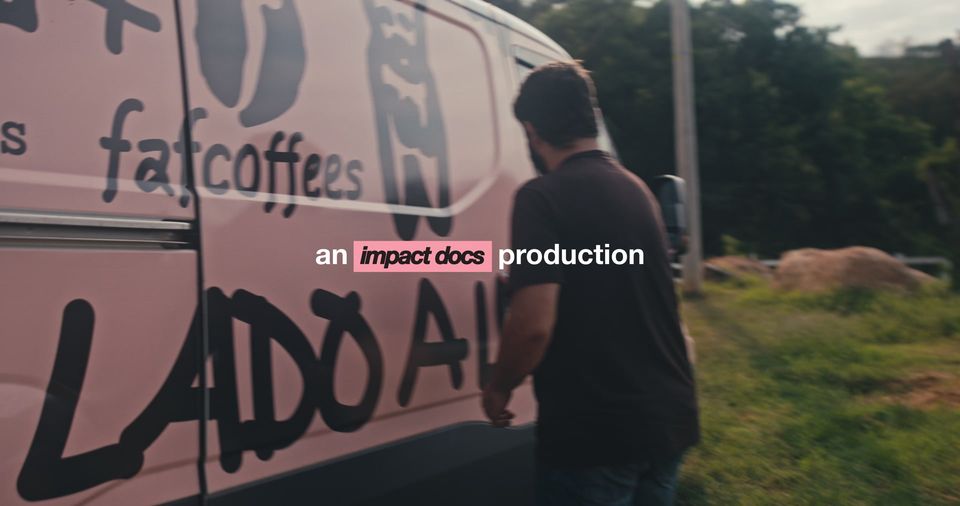 Opening of Lado a Lado: a man walks past a pink coffee van.