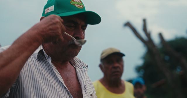 A farmer tasting coffee from a spoon.
